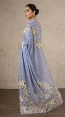 Back view of a model in a periwinkle blue floral lawn suit with a cascading printed bamber chiffon dupatta spread wide