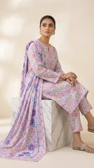 Model seated on a white marble cube in a soft lilac pastel medallion lawn suit with matching printed trouser and matching lilac chiffon dupatta with bold blue-outlined tropical star florals pooling on the floor, warm beige background