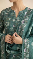 Full length front view of a model in a pine green floral lawn suit standing in a Moroccan courtyard archway with a cascading printed chiffon dupatta