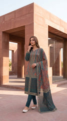 Close-up of the V-notch neckline with teal piping detail on a terracotta red luxury lawn kameez with all-over intricate paisley and floral jaal print in teal, gold, and ivory, teal chiffon dupatta draped alongside