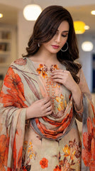 Close-up portrait of a model looking down and holding the cream-to-peach chiffon dupatta with oversized orange-red poppy and lily blooms, warm beige luxury lawn kameez with embroidered orange and gold neckline placket and scattered botanical floral print visible, modern living room background