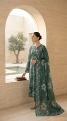 Portrait of a model wearing a pine green Pakistani lawn suit with a matching printed bamber chiffon dupatta draped over the head, gold circular earrings