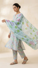 Full length front view of a model in a powder blue pastel medallion lawn suit standing under a Moroccan arch with desert plants in the background, contrast tropical floral chiffon dupatta flowing